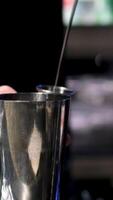 Bartender uses jigger to measure ingredients to create cocktail and pours liquids into shaker closeup slow motion. Professional training for barmen video