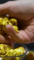 popcorn with caramel Female and Child Hands Grab Popcorn. Bowl of Caramel and Sweet Popcorn on Yellow Background. Top View Funny video