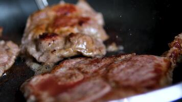 pork neck fry meat in a frying pan chef cooks a beef steak on a pan in the kitchen and turns it to the other side, food close-up. Process of making delicious steak. video