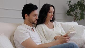 Couple enjoys quiet afternoon reading together on comfortable sofa video