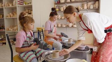Children learn pottery skills at a creative workshop in a sunny studio video