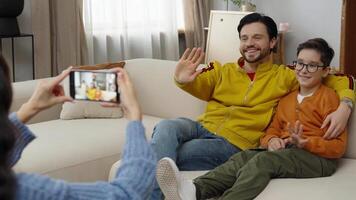 Father and son share a cheerful moment while posing for a family snapshot video