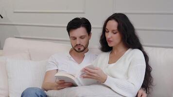 Couple enjoying a peaceful reading session at home on a cozy couch video