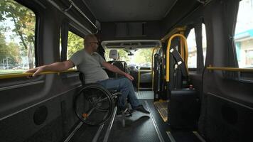 Person in wheelchair seated inside adapted vehicle, looking outside. video