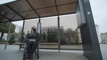 Woman in a wheelchair waiting for a bus at a bus stop 2 video