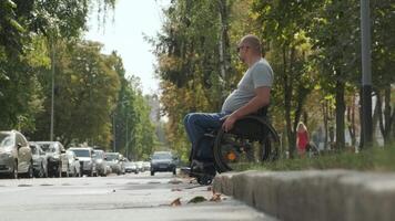 Wheelchair user positioned on the edge of a curb, preparing to cross. video