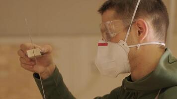 Hardworking professional carpenter in mask and glasses holding a ruler and pencil while measuring a wooden beam in a carpentry workshop. video