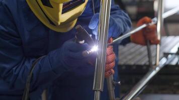 Man wearing mask welding in a workshop. Metal workers use manual labor. Skilled welder. Welder is welding the stainless steel pipes in the factory. welder Industrial part in factory. 9 video