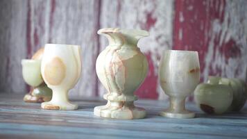 Unique handcrafted stone vases and cups displayed on a table video