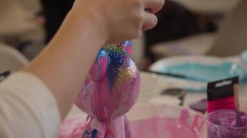 During the workshop, a freshly painted teddy bear figurine is sprinkled with glitter to make it more attractive and colourful. video