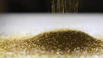 Golden synthetic diamond powder falling into a sparkling pile under soft light, Macro view of abrasive diamond grains used in precision grinding and cutting applications video