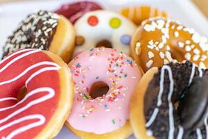 a close up image of a selection of flavoured donuts on a tray photo