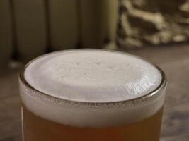 Chilled Beer in Drinkware with Foam on Tableware creative background photo