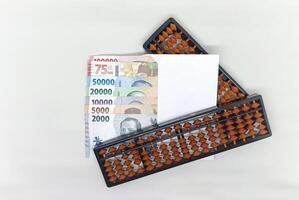 abacus and Indonesian banknotes in white envelope. Collection of banknotes in denominations 2000, 5000, 10000, 20000, 50000, 75000, 10000 rupiah photo