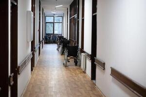 A row of wheelchairs neatly lined up in a hospital corridor, ready for patients in need of mobility assistance photo