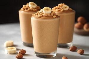 Deliciously creamy banana peanut butter smoothies topped with crunchy nuts in a cozy kitchen setting. Three tall glasses of smooth banana smoothies are garnished with sliced bananas and nuts photo