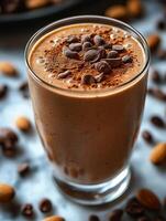 Delicious chocolate smoothie topped with cocoa and coffee beans in a glass with almonds scattered around. Protein chocolate smoothie served in tall glass, garnished with cocoa powder and coffee beans photo