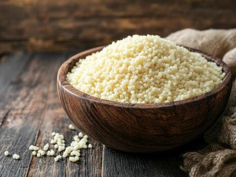 Couscous in a wooden bowl on a rustic table photo