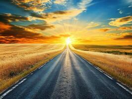 Vibrant sunset over open road leading through golden fields photo