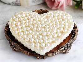 Elegant heart-shaped dessert adorned with pearl-like decorations photo