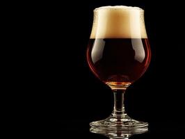 Craft beer in a glass with a frothy head against a dark background photo