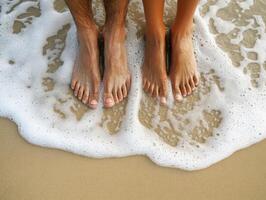 Couple standing barefoot in ocean waves at sunset beach photo