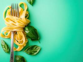 Fresh fettuccine with basil on a bright turquoise background photo