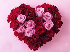 Heart-shaped arrangement of roses in various shades of red and pink photo