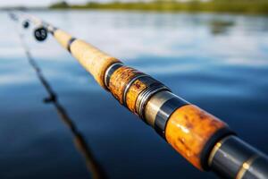 Fishing rod rests on shore near calm water during daytime photo