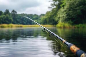 Fishing rod poised over tranquil river with lush greenery photo