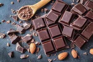 Dark chocolate pieces with almonds and cacao on a wooden table photo