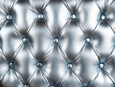 Textured silver upholstery with button details on a surface photo