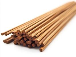 Natural wooden sticks arranged neatly in a pile on white background photo