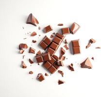 Chocolate pieces scattered on a white photo