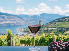 Glass of red wine in vineyard with lake and mountains in background photo