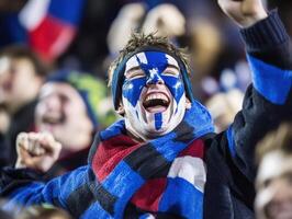 Cheering child with face paint at sports event shows team spirit photo