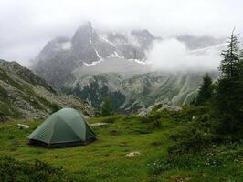 Mountain camping experience in serene landscape under cloudy skies photo