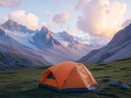 Camping in the mountains at sunset with an orange tent setup photo