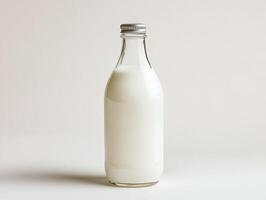 Fresh milk in a glass bottle on a minimalistic background photo