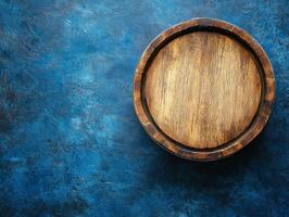A round wooden barrel on a deep blue textured surface photo