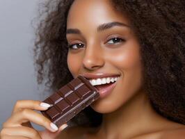 Woman enjoying chocolate with a joyful smile in a bright setting photo