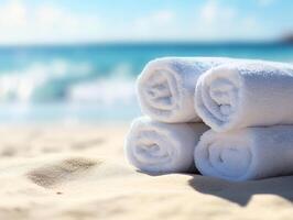 Towels resting on sandy beach near tranquil ocean waves photo
