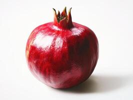 Vibrant red pomegranate sitting on a white surface photo