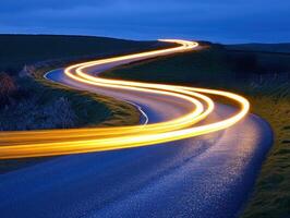 Curving country road illuminated by vehicle lights photo