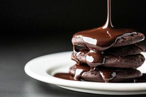 Decadent chocolate cookies stacked with rich sauce drizzling down photo