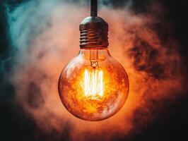 Vintage light bulb glows warmly in smoky atmosphere photo
