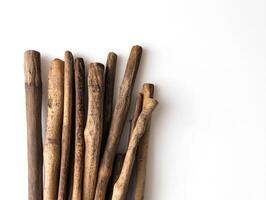 Collection of natural wooden sticks arranged on a white surface photo