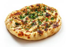 Garlic naan bread topped with fresh herbs on a white surface photo