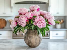 Fresh peonies in a rustic vase on a kitchen countertop photo