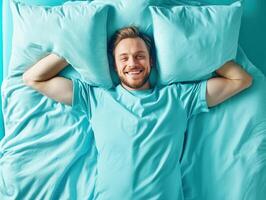 Man relaxing on a turquoise bed enjoying a moment of leisure photo